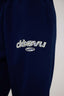 Navy blue sweatpants with 'dès vu' leopard logo on a white background