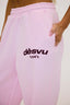 Pink joggers with burgundy dés vu logo on a white background