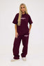 Person wearing a burgundy 'déévu' t-shirt and sweatpants on a white background