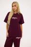 Woman wearing a burgundy 'dèsvu' t-shirt and pants on a white background