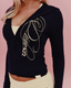 A close-up of a woman wearing a navy blue zip-up hoodie with a large yellow des vu graphic on the front, set against a solid pink background.