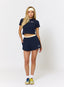 Woman wearing navy waffle baby tee and shorts with 'des vu' branding on a white background.