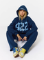 Woman wearing navy tracksuit with '422' branding on a white background.