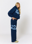 Woman wearing navy tracksuit with '422' branding on a white background.