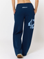 Woman wearing navy joggers with 'des vu' branding on a white background.