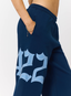 Closeup of woman wearing navy joggers with '422' branding on a white background.