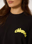 Closeup of a woman wearing black waffle long sleeve t-shirt with citron 'desvu' branding on a white background.