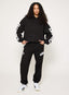 Black tracksuit with DÈS VU logo  on a plain background