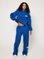 Person wearing a blue tracksuit with a brand logo on a white background