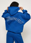 Person wearing a blue hoodie with 'Fenty' branding on the back against a white background