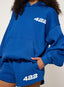 Person wearing a blue hoodie and shorts set with '422' logo on a plain background