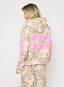 Person wearing a camouflage hoodie with pink text on a white background