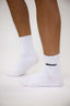 White crew socks with DÈS VU logo on a light background