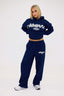 Person wearing a navy blue tracksuit with 'DÈS VU' branding on a white background
