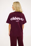 Person wearing a burgundy t-shirt with 'dèsvu' logo on the back against a white background