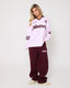 Person wearing a pink and maroon tracksuit with 'desvi' branding on a white background