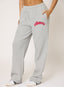 Woman wearing grey waffle joggers with coral 'desvu' branding on a white background.