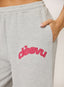 Closeup of grey waffle joggers with coral 'desvu' branding on a white background.