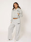 Woman wearing a grey polka dot tracksuit with 'desvu' branding on a white background.