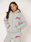 Woman wearing grey waffle hoodie with coral 'desvu' branding on a white background.