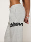 Grey tracksuit with DÈS VU logo  on a plain background