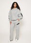 Grey tracksuit with DÈS VU logo  on a plain background