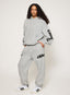 Grey tracksuit with DÈS VU logo  on a plain background
