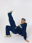 Woman wearing navy tracksuit with leopard print pattern 'des vu' branding on a white background.