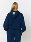 Woman wearing navy tracksuit with leopard print '422' branding on a white background.