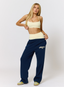 Woman wearing navy joggers with leopard print pattern 'des vu' branding on a white background.