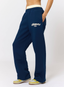 Woman wearing navy joggers with leopard print pattern 'des vu' branding on a white background.