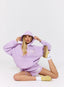 Woman wearing lilac hoodie and shorts with '422' branding on a white background.