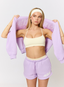 Woman wearing lilac shorts with '422' branding on a white background.
