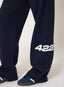 Closeup of woman wearing navy joggers with '422' branding on a white background.