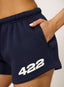 Woman wearing navy shorts with '422' branding on a white background.
