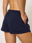 Woman wearing navy shorts with '422' branding on a white background.