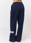 Woman wearing navy joggers on a white background.