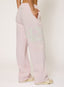 Woman wearing light pink joggers with '422' branding on a white background.