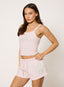 Woman wearing light pink shorts with studded '422' logo on a white background.