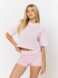 Woman wearing pink striped t shirt with 'des vu' branding on a white background.