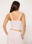 Woman wearing pink double layer vest top on a white background.