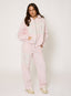 Woman wearing light pink tracksuit with '422' branding on a white background.