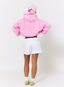 Woman wearing pink hoodie on a white background.