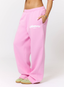 Woman wearing pink joggers with 'des vu' branding on a white background.