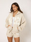 Woman wearing unzipped stone hoodie with '422' branding on a white background.