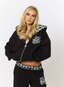 Woman wearing black hoodie with teddy plaid print 'des vu' branding on a white background.