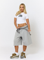 Woman wearing white t-shirt with teddy plaid print 'des vu' branding on a white background.